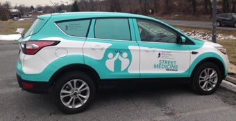 picture of suv with white and turquoise branding on exterior for Street Medicine