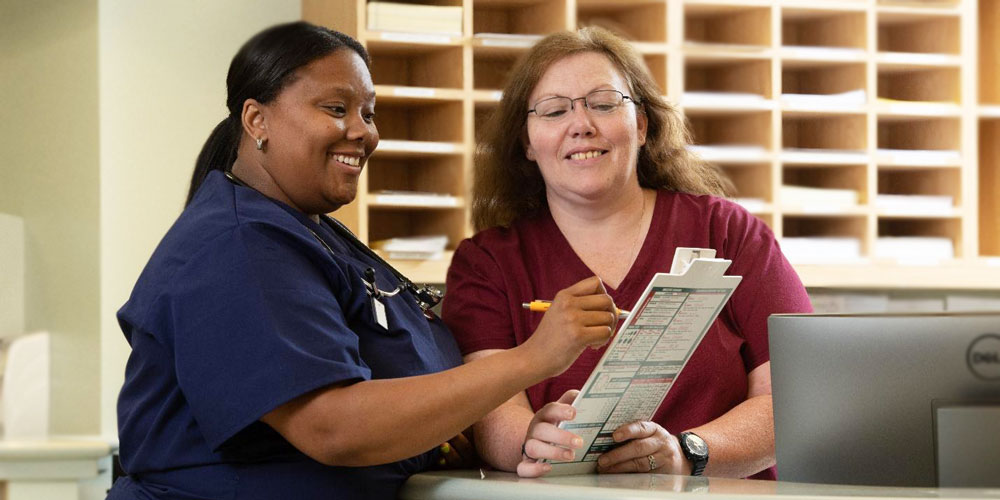 two nurses signing paper