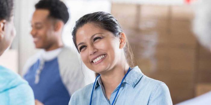 Woman smiling with badge around her neck.